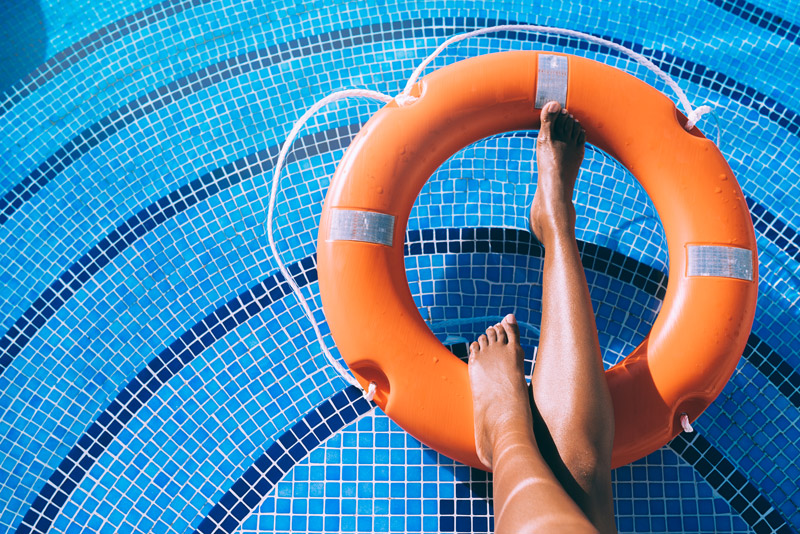 woman legs swimming pool with lifesaver
